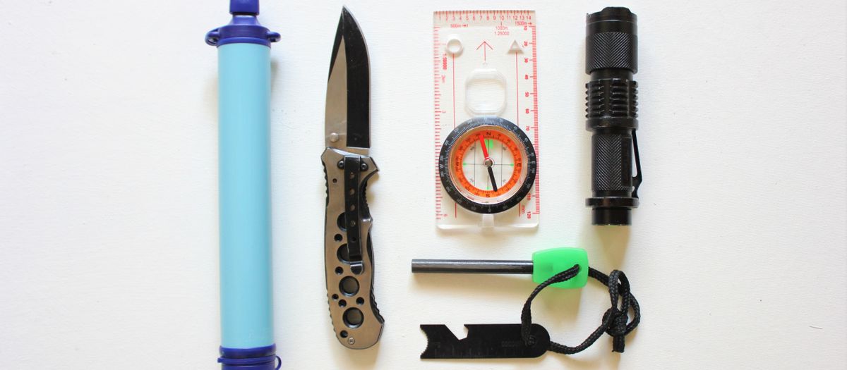 Flatlay of essential survival kit items on a white background